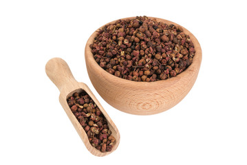 sichuan pepper in wooden bowl and scoop isolated on white background. 45 degrees view. spices and food ingredients