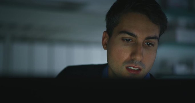 Slow motion close up of a young handsome businessman is working with a computer in a office.