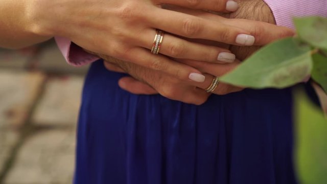Hands of the bride and groom with wedding rings.