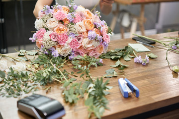 European floral shop concept. Florist woman creates beautiful bouquet of mixed flowers. Handsome fresh bunch. Education, master class and floristry courses. Flowers delivery.