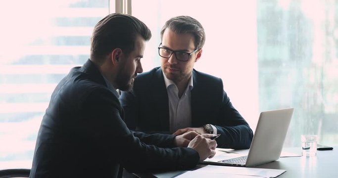 Two successful businessmen wear suits handshake at business meeting