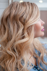 Naklejka premium portrait of a blonde girl with curly hairstyle