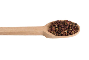 sichuan pepper in wooden spoon isolated on white background. spices and food ingredients