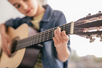 Blurred kid learning to play guitar