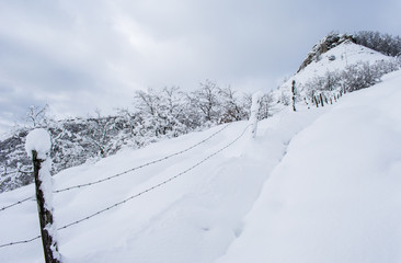 Fototapeta na wymiar Barbed wire on a snowy mountain