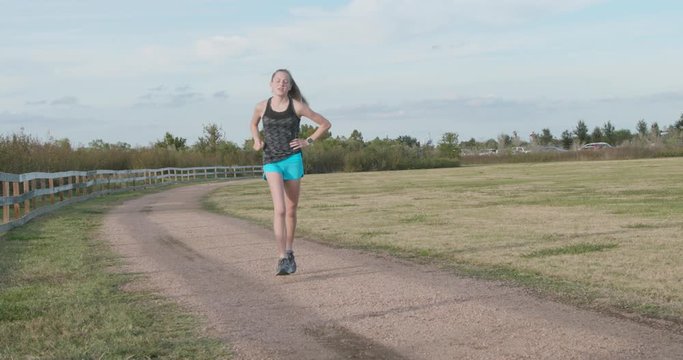 A teenage girl with a passion for long distance running slows down when she starts experiencing pain in her side from exertion.