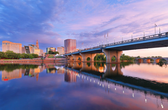 The skyline of Hartford, Connecticut at sunrise. Photo shows Founders Bridge and Connecticut River. Hartford is the capital of Connecticut. 