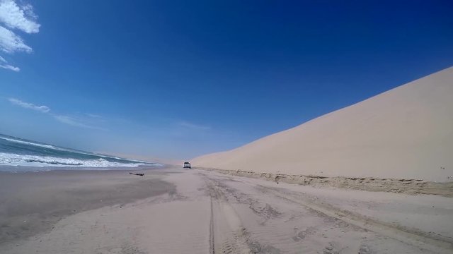 Safari 4x4 driving in the Namib desert by the Atlantic ocean on the skeleton coast, Namibia.
