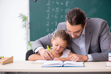 Teacher with young girl in the classroom