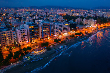 Aerial view of Limassol promenade in Cyprus at night. Drone photo of mediterranean sea resort from above.