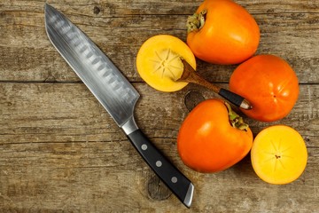 Ripe orange persimmon fruit.Kaki fruit on wooden table.Slices of persimmon.Set of kakis. Fruits of Kaki Persimmon (Diospyros kaki) in japanese autumn