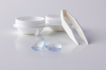 Contact lenses, case and tweezers on white background. Eye health and care, eyesight and vision, ophthalmology and optometry