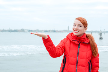 woman smiling showing with open palm the sea