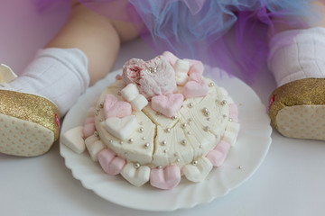 first cake. pink cake. the child takes the cake with his hand. hand in pastry cream. children's holiday
