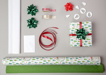Wrapping Christmas gift on the table, directly above view on wrapping paper, bows and ribbons, decorative items for wrapping gift boxes	