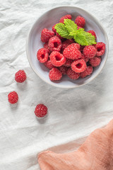 Bowl of delicious fresh ripe raspberries on table, closeup view