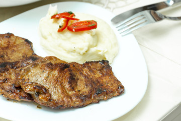 mashed potatoes and fried beef steak in white plate
