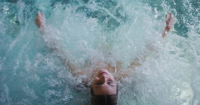 Close up of an young female is enjoying and having relax in a bath tube in a luxury wellness center.