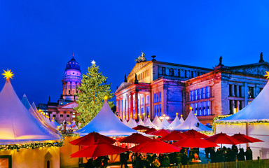 Night Christmas Market of Gendarmenmarkt in Winter Berlin, Germany. German street Xmas and holiday fair. Advent Decoration and Stalls with Crafts Items on the Bazaar.