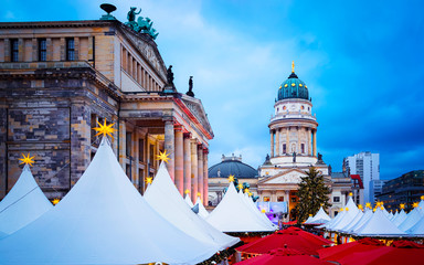 Fototapeta premium Night Christmas Market of Gendarmenmarkt in Winter Berlin, Germany. German street Xmas and holiday fair. Advent Decoration and Stalls with Crafts Items on the Bazaar.
