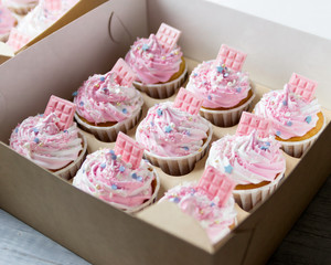 Delicious cupcakes with pink and white cream in a box for cakes.