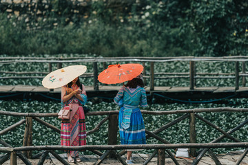 Tourists take photos against the fields of flowers in the small little mountain village of Cat Cat