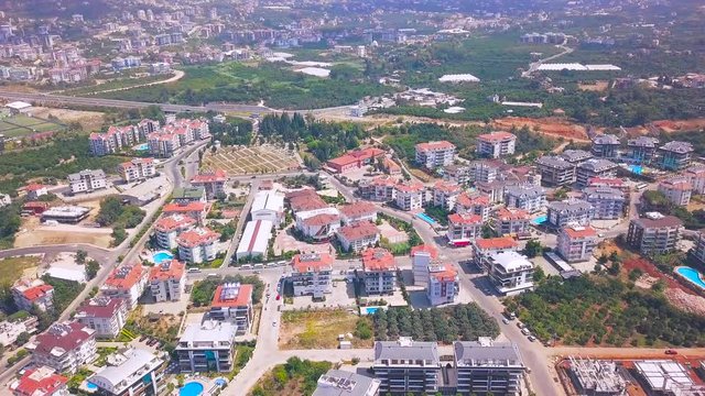 Aerial panoramic view of summer city with luxury houses, swimming pools, hotels and green trees. Clip. Flying above the south city.