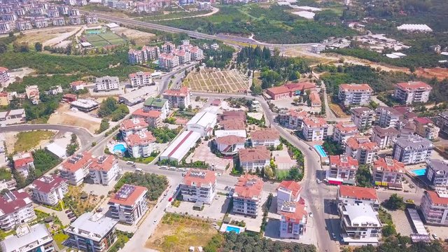 Aerial panoramic view of summer city with luxury houses, swimming pools, hotels and green trees. Clip. Flying above the south city.