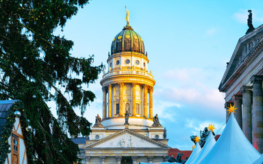 Fototapeta premium Night Christmas Market of Gendarmenmarkt in Winter Berlin, Germany. German street Xmas and holiday fair. Advent Decoration and Stalls with Crafts Items on the Bazaar.