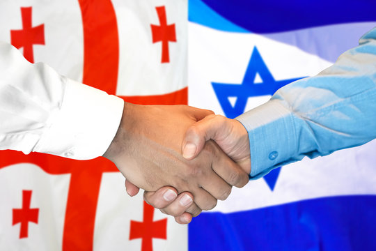 Business handshake on the background of two flags. Men handshake on the background of the Georgia and Israel flag. Support concept