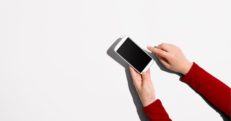 Person using a white smartphone - overhead view