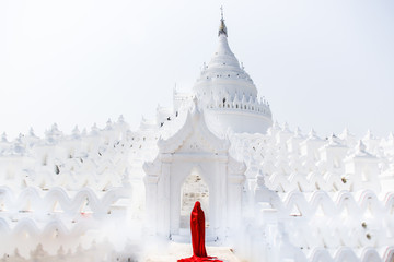 Creature in a red floaty robe walking along ancient Myanmar Buddhist temples and stupas...