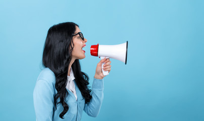 Young woman with a megaphone on a blue background