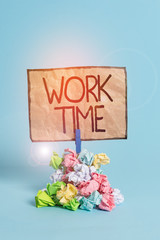 Word writing text Work Time. Business photo showcasing period starts when temporary workers are engaged at a worksite Reminder pile colored crumpled paper clothespin reminder blue background