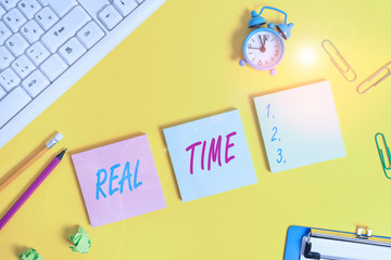 Writing note showing Real Time. Business concept for the actual time during which a processes or events occurs Flat lay above copy space on the white crumpled paper
