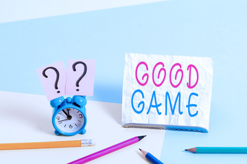 Writing note showing Good Game. Business concept for term frequently used in multiplayer gaming at the end of a match Mini size alarm clock beside stationary on pastel backdrop