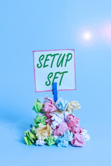 Handwriting text Setup Set. Conceptual photo the analysisner, position, or direction in which something is set Reminder pile colored crumpled paper clothespin reminder blue background