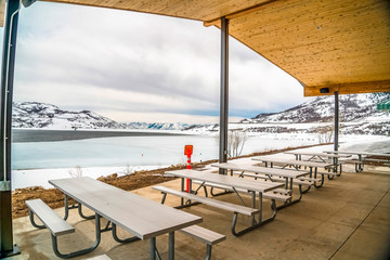 Picnic pavilion overlooking a snowy winter landscape of lake and mountain