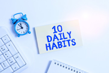 Conceptual hand writing showing 10 Daily Habits. Concept meaning Healthy routine lifestyle Good nutrition Exercises Keyboard with empty note paper and pencil white background