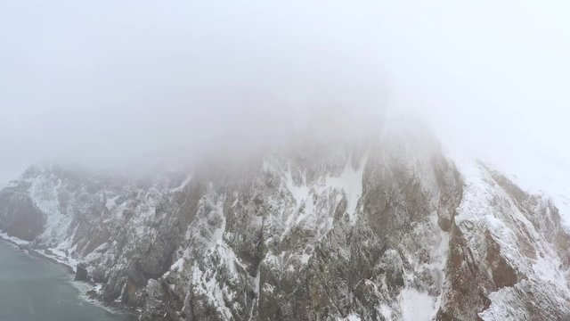 Shooting of rocks and the seashore when it is snowing from the drone. Place of shooting northwest coast of the Bering Sea, Chukchi region.