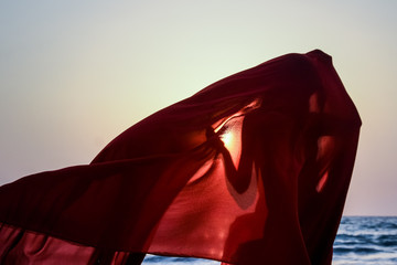 Creature in a red floaty robe standing on the beach sunset golden hour silhouette Ngapali beach Myanmar