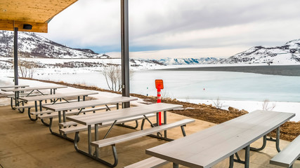 Panorama Picnic pavilion overlooking a snowy winter landscape of lake and mountain