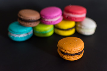 macarons franceses de colores sobre fondo infinito negro