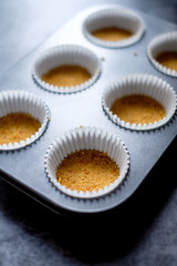 Mini Cheesecakes Recipe. Biscuits mix with butter on 6 muffin liners in a muffin pan.