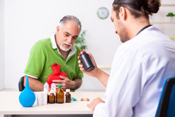 Old man visiting young male doctor gastroenterologist
