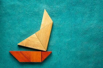 tangram sailboat over turquoise paper