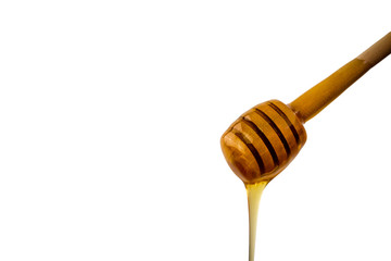 honey dripping from wooden dipper on a white background
