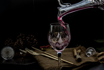 Flat lay composition with Pouring red wine from pitcher into the wineglass : traditional winemaking...