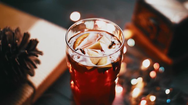 Mulled wine in glass on black wooden table in awesome background lights