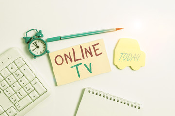 Word writing text Online Tv. Business photo showcasing a television production broadcast in realtime as events happen Copy space on empty note paper with clock and pencil on the table